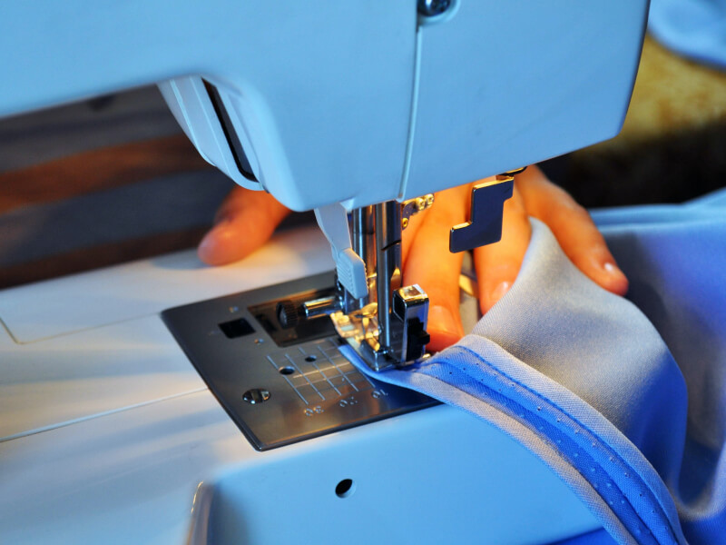 meone uses a sewing machine to stitch a zip
